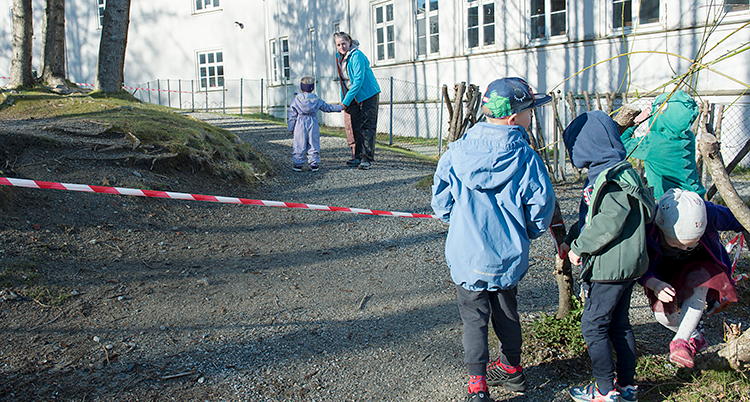 Barn går under ett rött och vitt rep