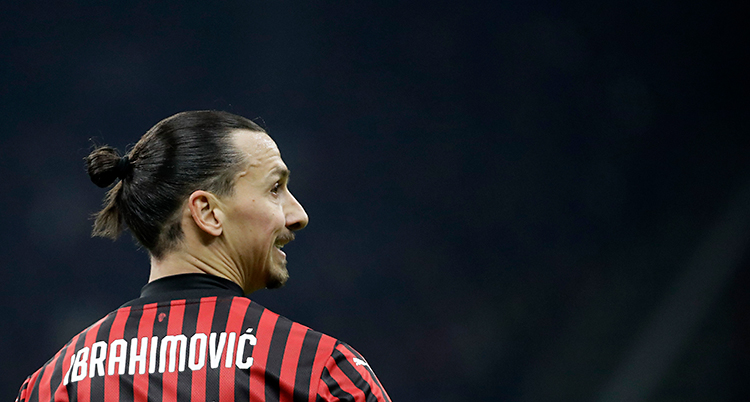 Zlatan på en match. Han har en tröja som är randig i svart och rött. Han har håret i en knut på huvudet.
