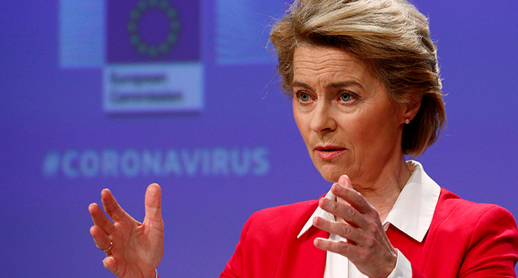 Ursula von der Leyen i röd kavaj måttar med händerna framför sig.