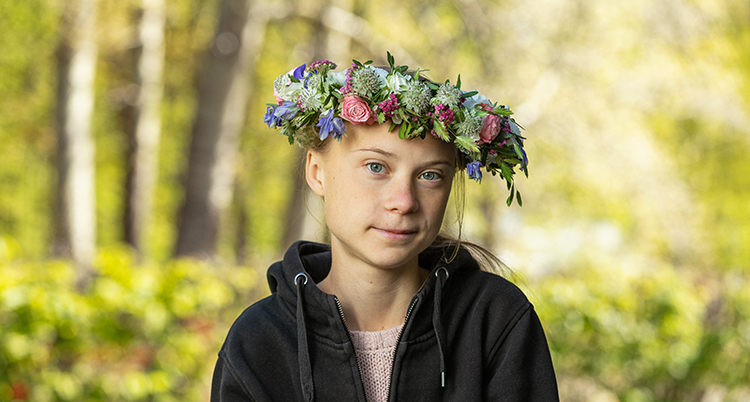 En bild på Greta Thunberg med blomsterkrans i håret.