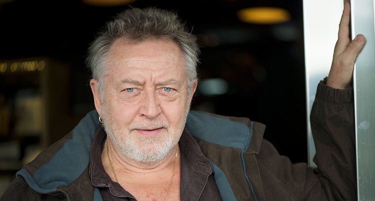 Ulf Lundell lutar sin arm mot väggen.