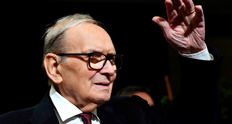 Ennio Morricone har på sig glasögon och skjorta med slips.