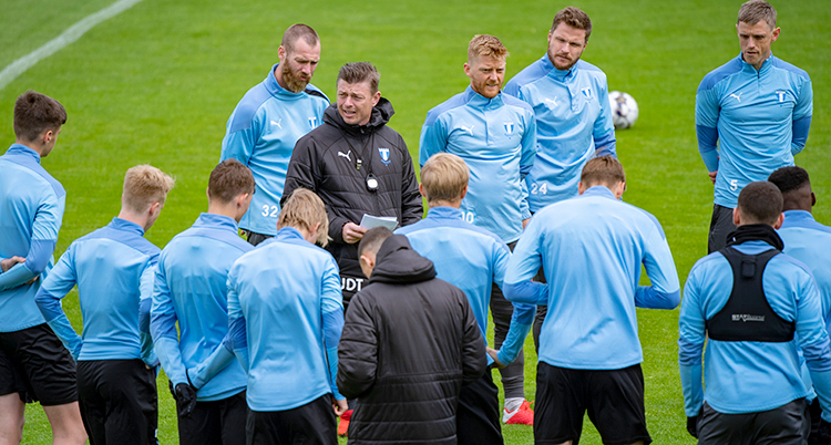 Spelare i träningskläder är samlade runt Malmös ledare.