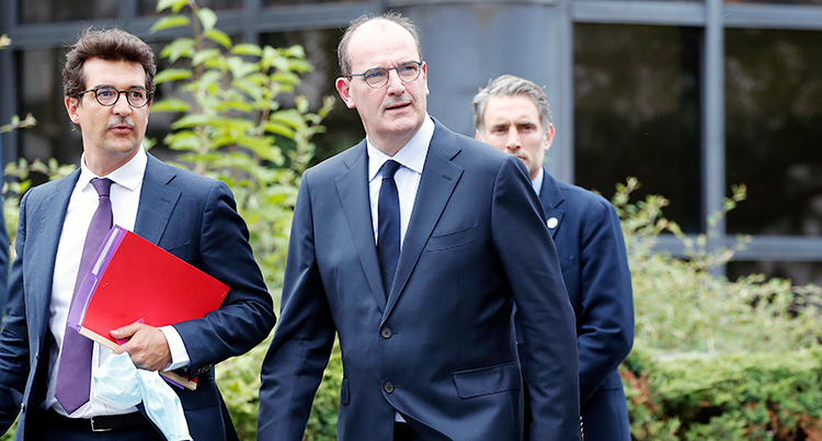 Frankrikes nya premiärminister Jean Kasta promenerar till ett möte med två andra män. Han har på sig en blå kavaj och slips.