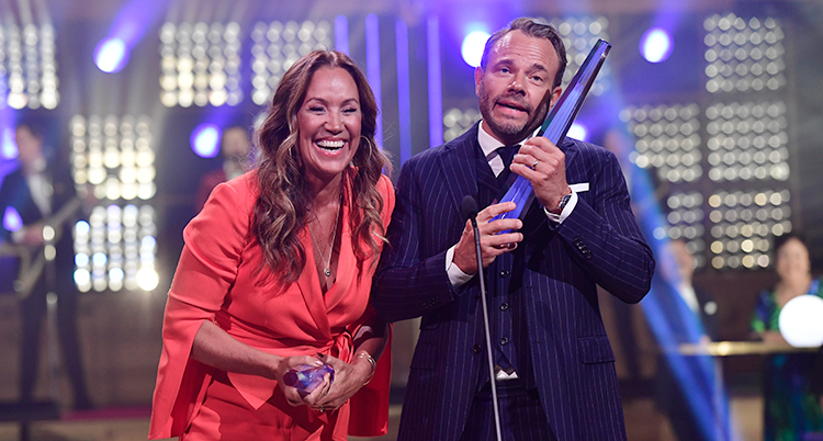 Renée Nyberg och David Hellenius ser glada ut när de tar emot priset Kristallen på scen.