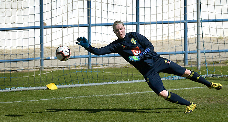 Hedvig Lindahl på en träning. Hon står i mål. Hon kastar sig mot en boll som kommer.