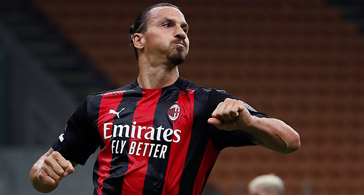 Bilden är från en match i fotboll. Zlatan har en tröja som är svart och röd.