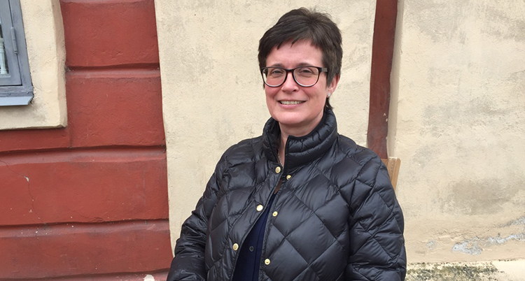 Åsa Storck i täckjacka sitter utomhus.