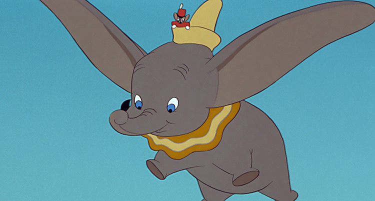 En tecknad elefant. Elefanten flyger med sina öron. Elefanten har en hatt där det sitter en mus.