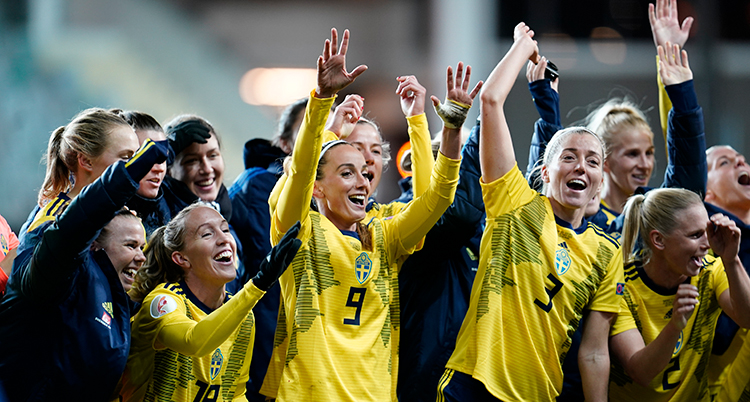 Flera svenska spelare jublar och håller upp händerna. De står tätt tillsammans.
