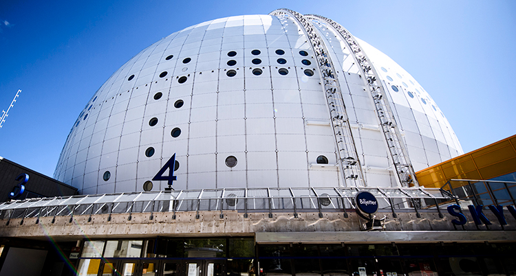 Den stora vita runda byggnaden Globen syns mot en blå himmel.