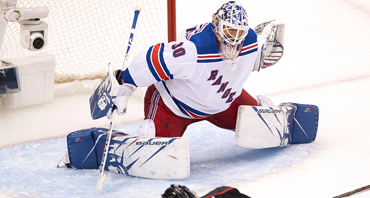 Lundqvist räddar ett skott. Han har benen brett isär och armarna ute.