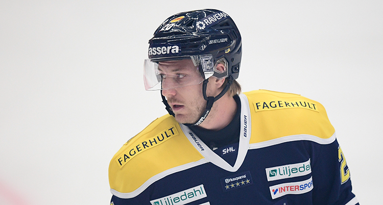 Han har en svart hockeyhjälm på huvudet och en svartgul tröja.