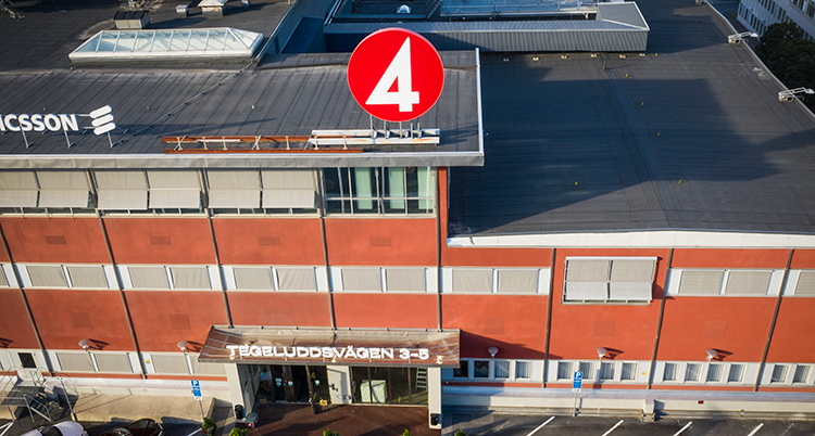 En bild på TV4s hus tagen uppifrån så man ser taket och framsidan. En rund skylt med en 4:a är på taket
