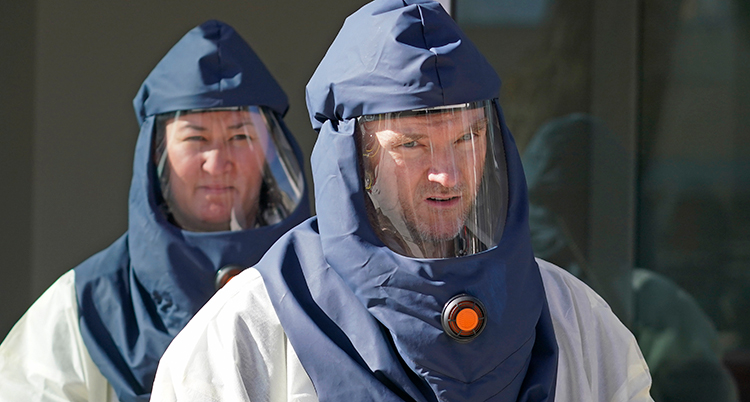 Två personer i stora masker över hela huvudet.