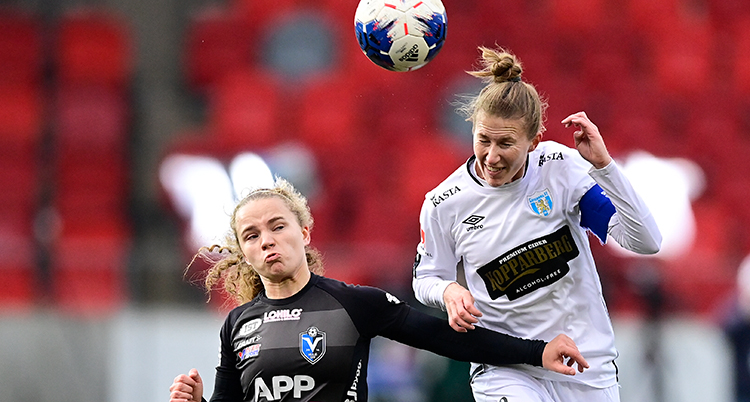 Två spelare i kamp om bolen. En har precis nickat och bollen är i luften.