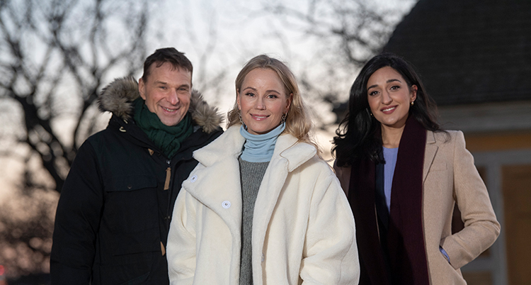 Tre personer tittar in i kameran, en man och två kvinnor. De står utomhus på Skansen.
