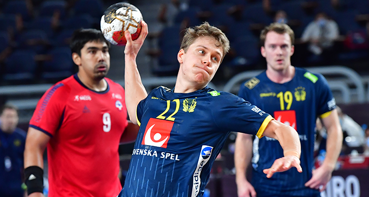 En spelare i blå tröja är på väg att skjuta ett skott. Två andra spelare står bakom och tittar.