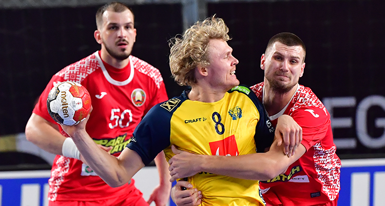 En svensk spelare med bollen stoppas av två belaruser.