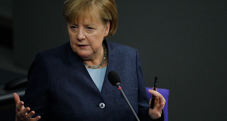 Angela Merkel vid en mikrofon.