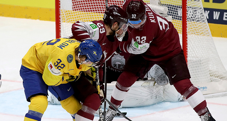 Spelarna kämpar om pucken framför målet med en målvakt
