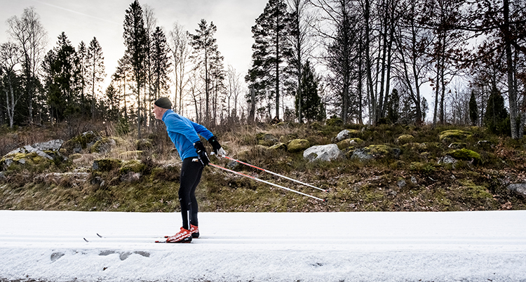 en man åker skidor i ett spår.