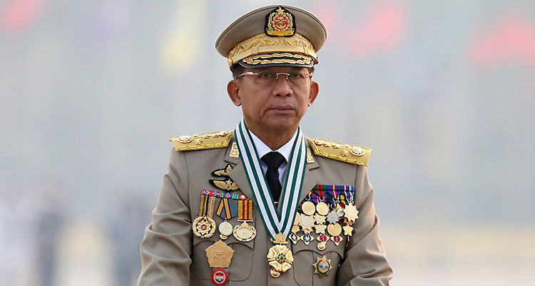En man som är klädd i en kostym för militärer. Han har en militärhatt på huvudet. Han har massor av medaljer på kavajen.