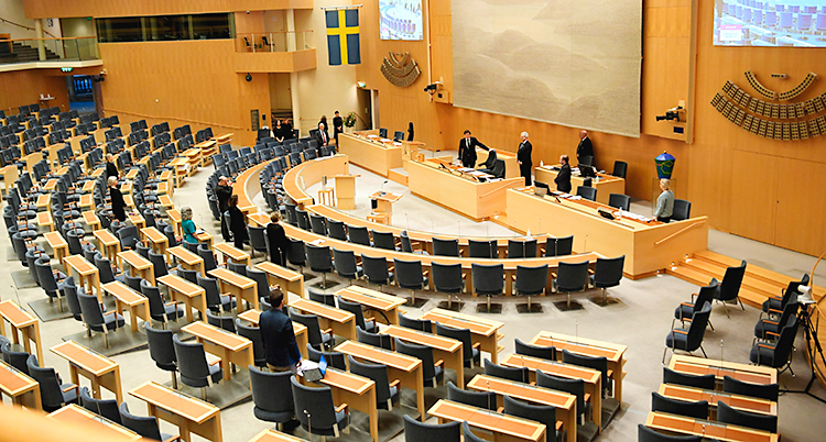 En bild från den stora salen i riksdagens hus. Några politiker har samlats.