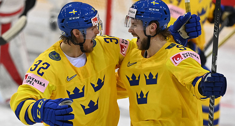 Två spelare tittar på varandra och skrattar. De är på väg att krama varandra.