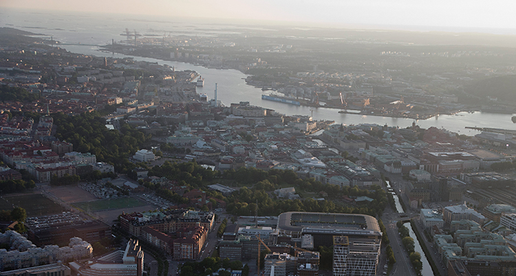 En bild på Göteborg som är tagen från ett flygplan. Vi ser massa hus, Göta älv och havet.