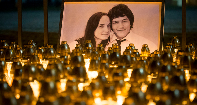 Gravljus framför bild på den mördade journalisten Ján Kuciak och hans flickvän Martina Kusnirova.