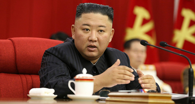 Kim Jong-Un i en röd sammetsstol. På bordet framför står en vit kopp.