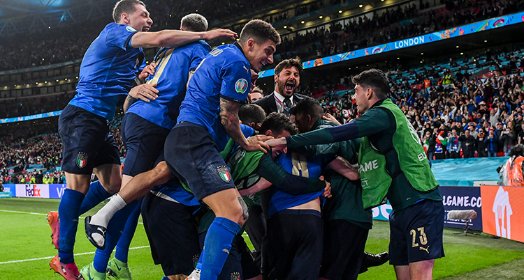 Fotbollsspelarna i blå tröjor kramar om varandra på planen.