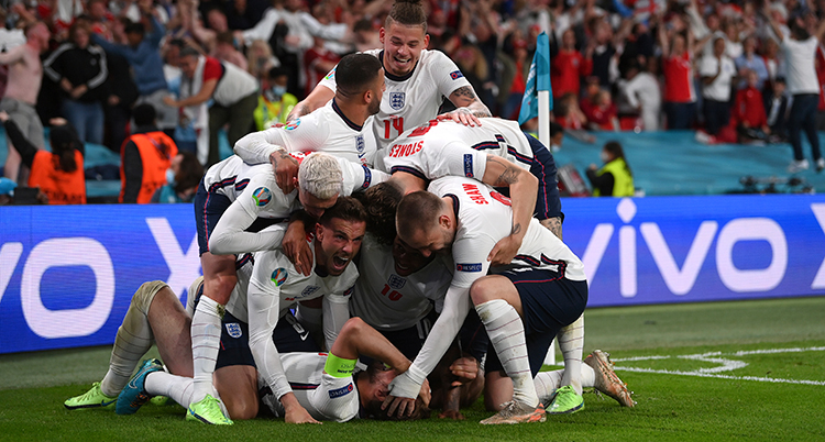 Englands spelare i vitt kramas på planen.