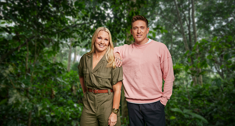 Han har rosa tröja och håller ena armen på hennes axel. Hon har bruna kläder. De står intill varandra och tittar in i kameran. Bakom syns grön regnskog.