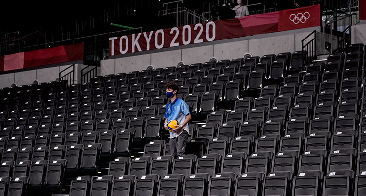 En man på en helt rom läktare. Bakom dom är en skylt där det står Tokyo 2020.