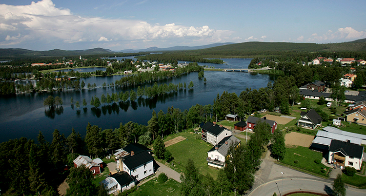 Staden ses från luften, med vy över älven och skogen.