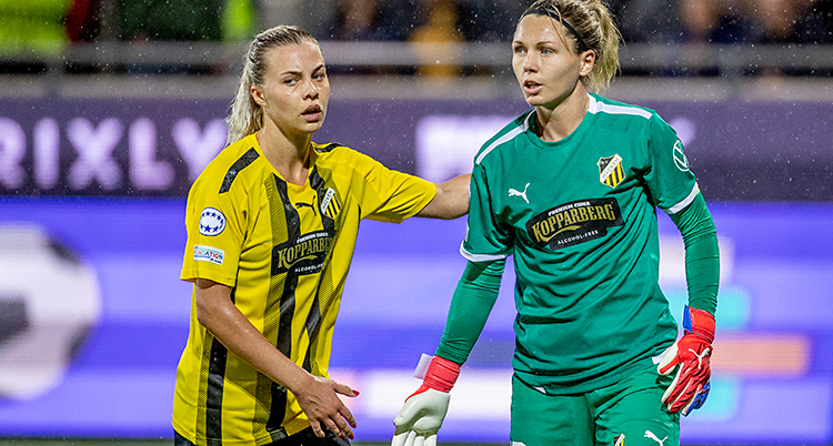 Från en match i fotboll. Två spelare pratar med varandra.