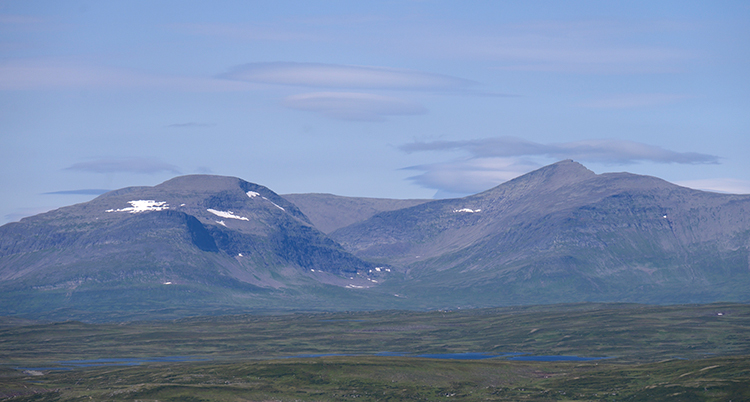 Fjällen syns och ovanför dem en klarblå himmel.