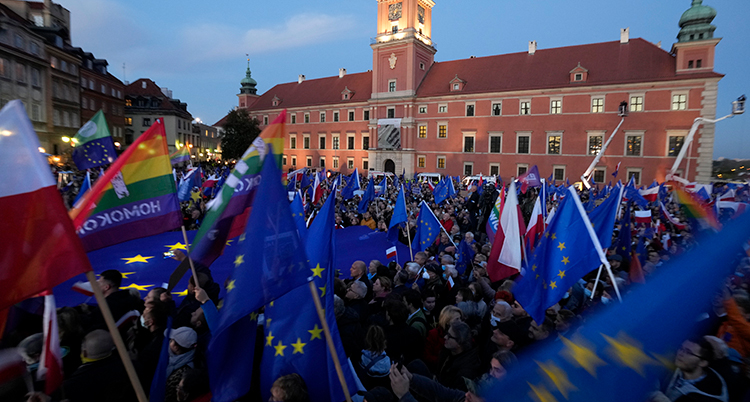 eu-flaggor och massor av människor som protesterar.