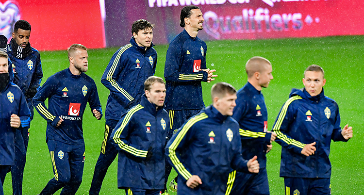 Några spelare som springer på en fotbollsplan.
