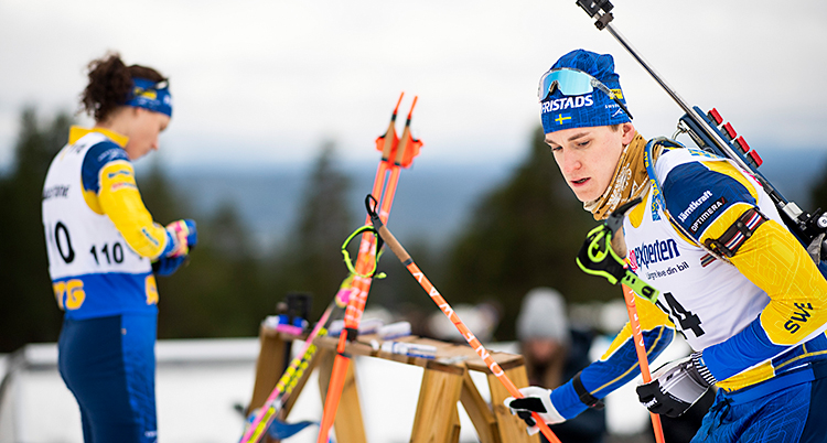 Martin gör sig redo för att åka iväg med skidorna. Hanna står i bakgrunden.