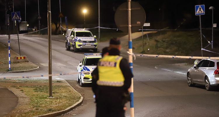 Poliser arbetar vid mordplatsen.