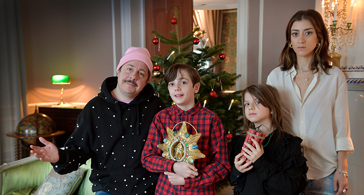 De står bredvid varandra. Ett av barnen håller i en julstjärna.