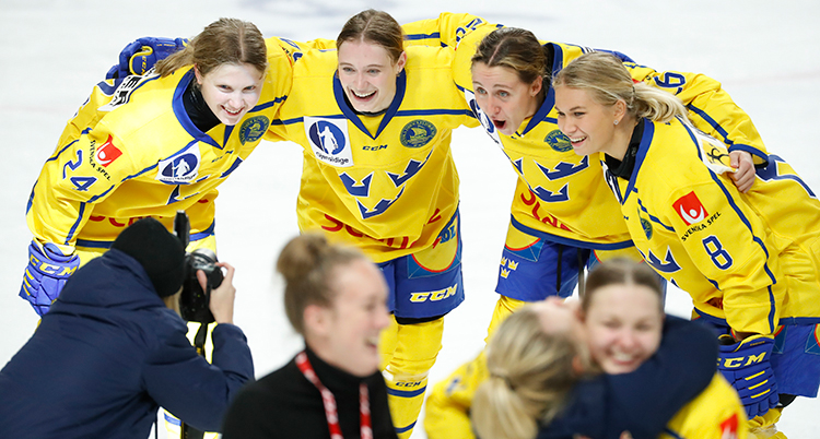 De står i en halvcirkel och håller om varandra. De blir fotograferade