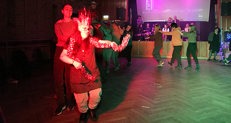 De dansar i en sal med händerna på varandras axlar.