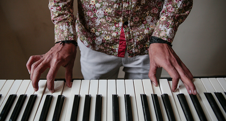 Tvä händer spelar på ett piano.