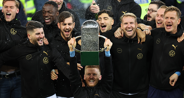 Fotbollsspelaren Anders Christiansen lyfter en pokal. Malmö FF har vunnit guld.