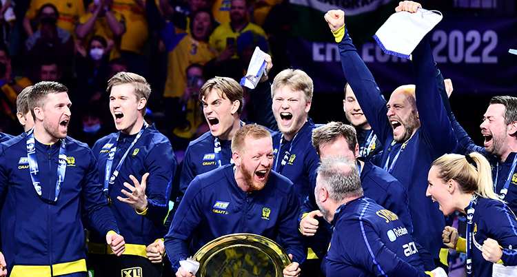 Flera herrar i mörkblå tröjor skriker och är glada.