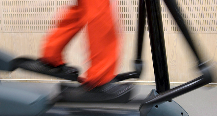 Ett par ben går på en crosstrainer.